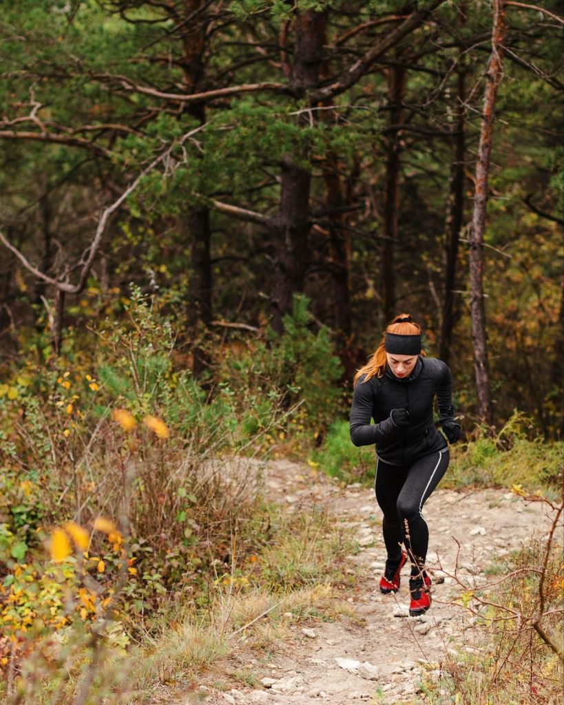 Ejemplo de texto Alt para SEO: Corredora de trail running con equipación técnica ascendiendo por montaña